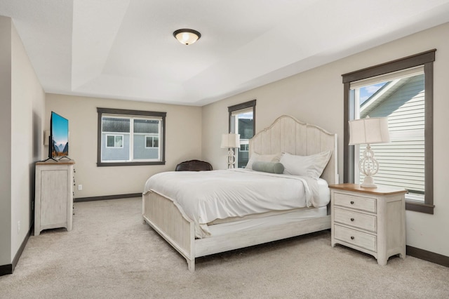 bedroom featuring light carpet and baseboards