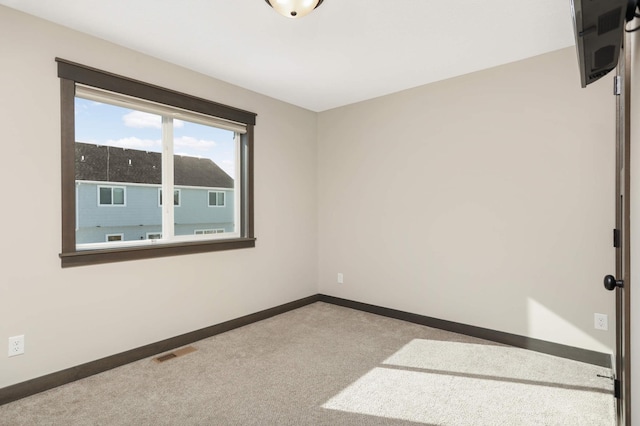 empty room featuring visible vents, carpet floors, and baseboards