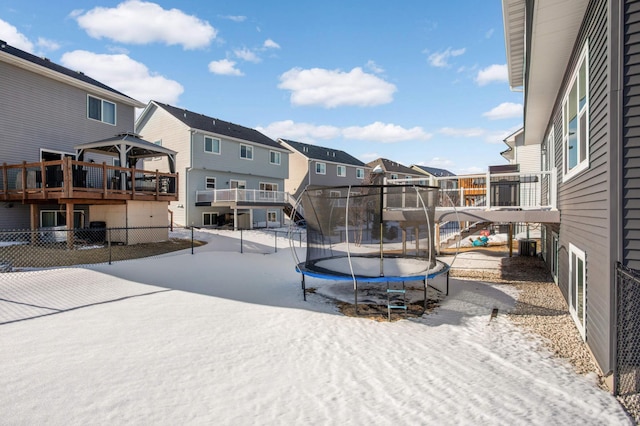 exterior space featuring a residential view, a trampoline, and fence