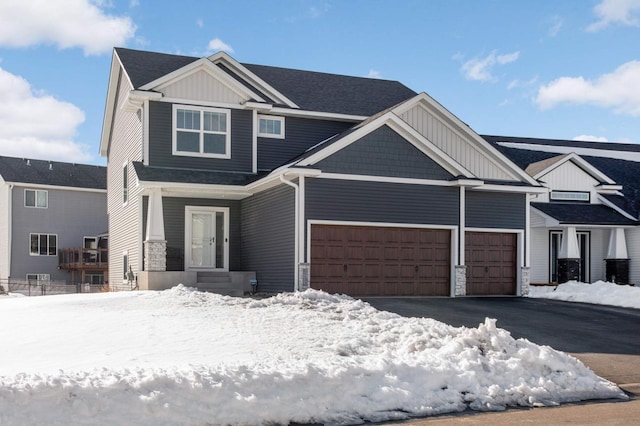 view of front of property with a garage, stone siding, board and batten siding, and aphalt driveway