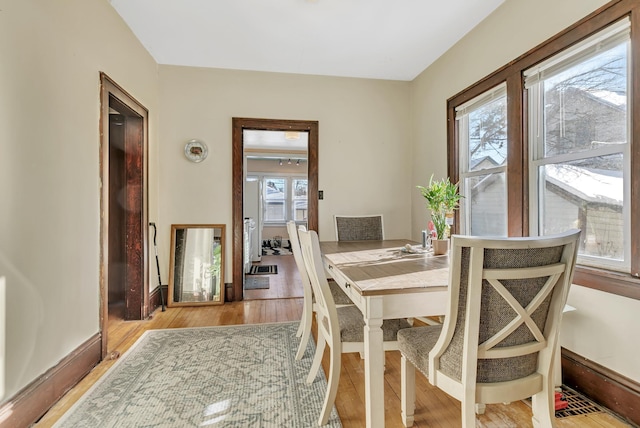 dining room with baseboards and light wood-style floors