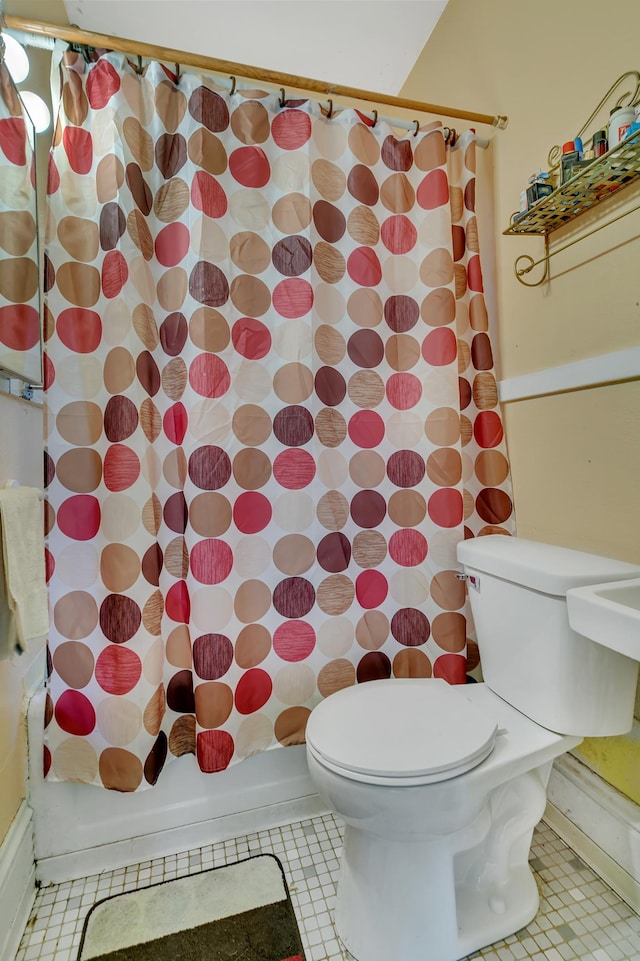 full bath with toilet, shower / tub combo, and tile patterned flooring