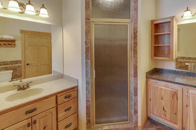 full bathroom featuring toilet, tile patterned floors, a shower stall, and vanity