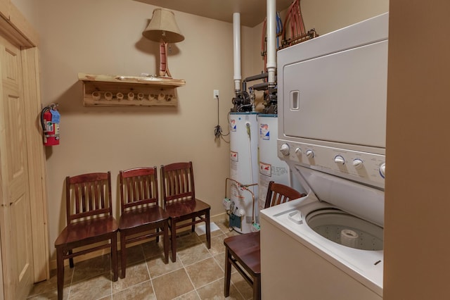 clothes washing area with laundry area, water heater, light tile patterned floors, and stacked washer and clothes dryer