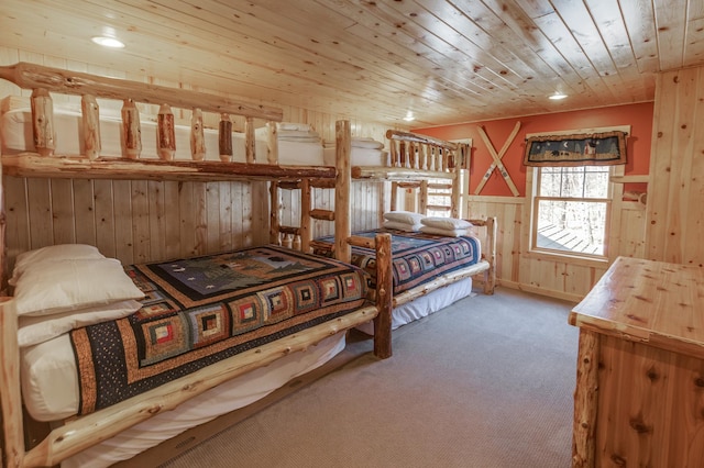 bedroom with carpet floors, wooden ceiling, and wooden walls