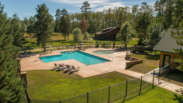 pool featuring fence, a community hot tub, a patio, and a yard