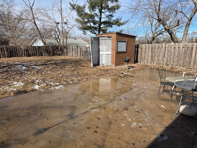 view of patio / terrace featuring a storage shed, a fenced backyard, and an outbuilding