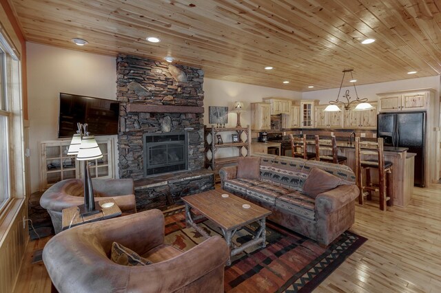 living room featuring recessed lighting, wood ceiling, a fireplace, and light wood-style flooring