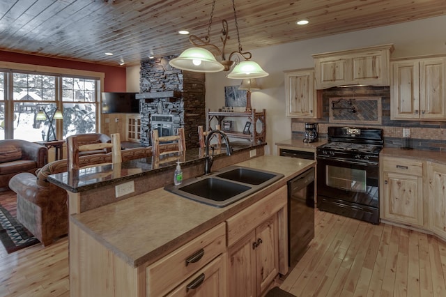 kitchen featuring a kitchen island, open floor plan, a sink, and black appliances