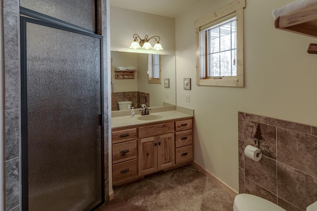 bathroom featuring baseboards, toilet, tile patterned flooring, vanity, and a shower stall