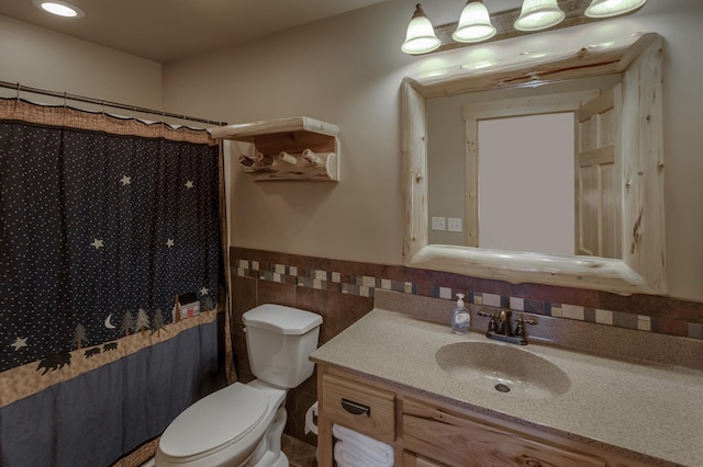 bathroom featuring a wainscoted wall, tile walls, curtained shower, toilet, and vanity