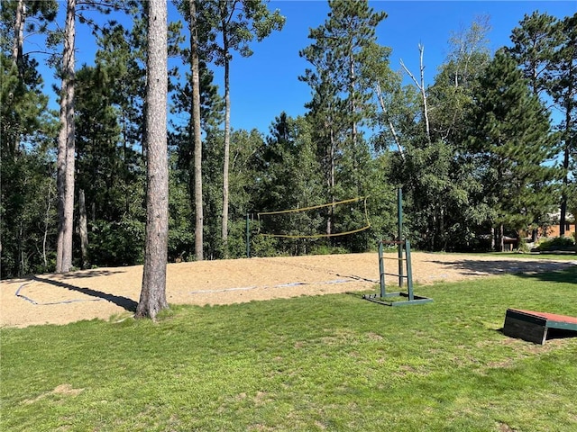 view of property's community featuring a lawn and volleyball court