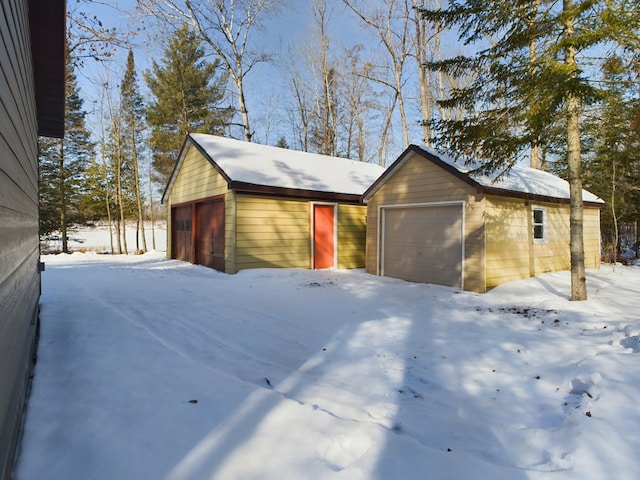 snow covered garage featuring a detached garage