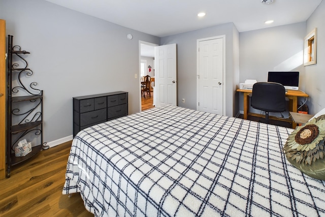 bedroom featuring baseboards, wood finished floors, and recessed lighting