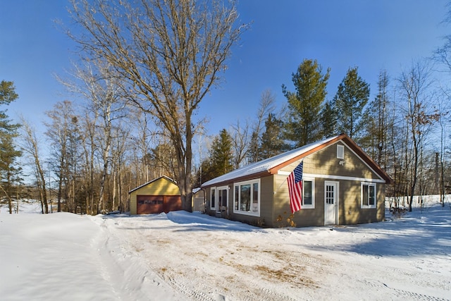 view of front facade with a detached garage and an outdoor structure