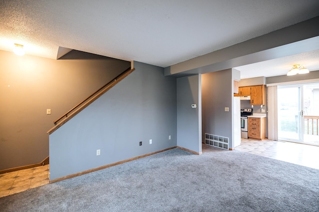 unfurnished living room with baseboards, stairs, visible vents, and light colored carpet