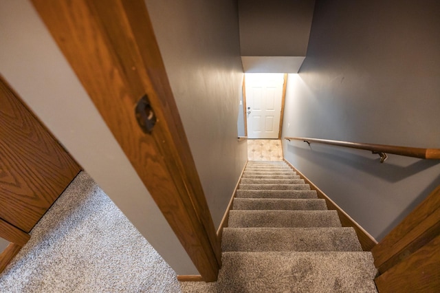 stairway with baseboards and carpet flooring