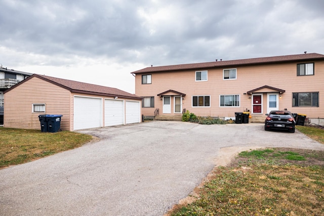 view of property with a garage and a front lawn