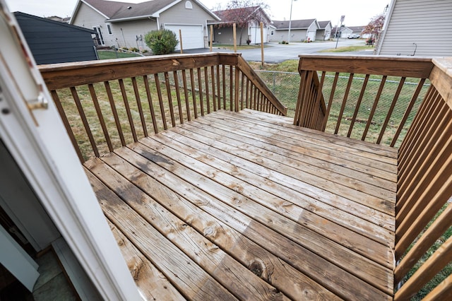 wooden deck featuring a yard, a residential view, and fence