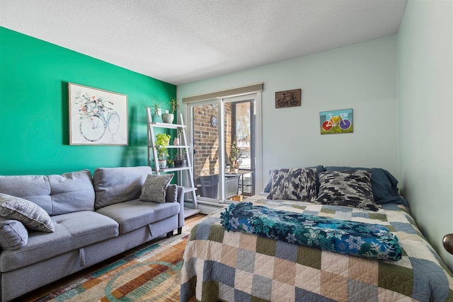 bedroom with a textured ceiling and wood finished floors