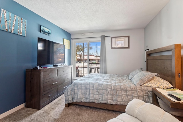 carpeted bedroom with access to exterior, a textured ceiling, and baseboards