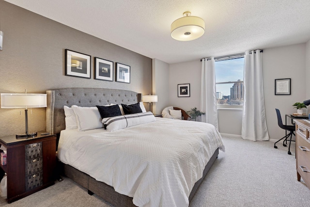 bedroom featuring a textured ceiling, baseboards, and light carpet