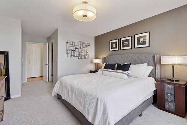 carpeted bedroom featuring baseboards and a textured ceiling