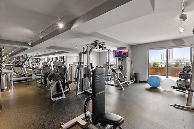 exercise room with rail lighting and baseboards