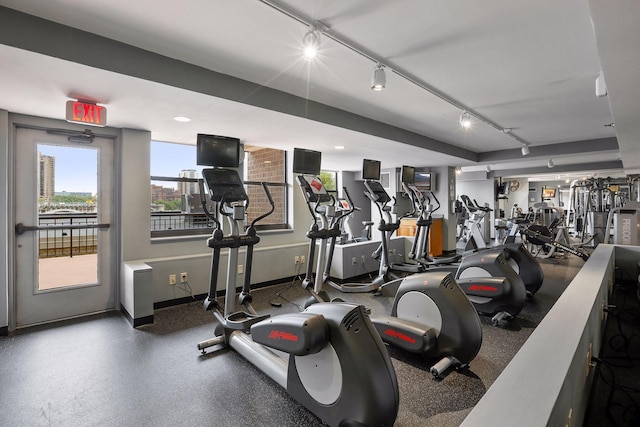 exercise room with rail lighting and baseboards