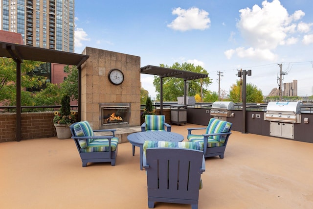 view of patio / terrace with exterior kitchen, an outdoor living space with a fireplace, and a grill