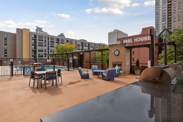 view of patio with a community pool and fence