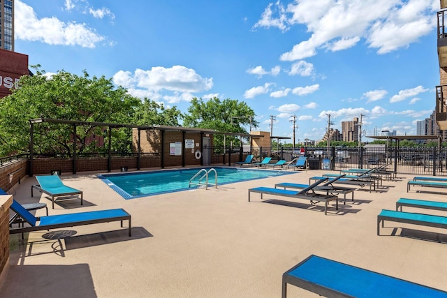 community pool featuring a patio and fence