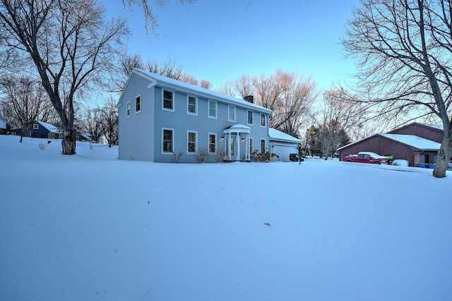 colonial-style house with entry steps and a chimney