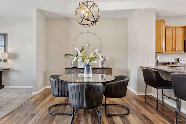 dining room with dark wood-style floors, a textured ceiling, and baseboards