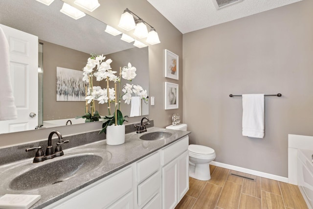 bathroom featuring wood finish floors, visible vents, a sink, and double vanity