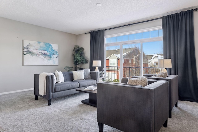 living area featuring carpet, baseboards, and a textured ceiling