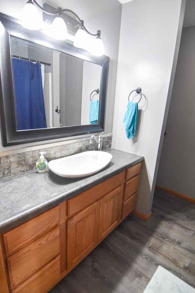 bathroom featuring a shower with shower curtain, wood finished floors, and vanity