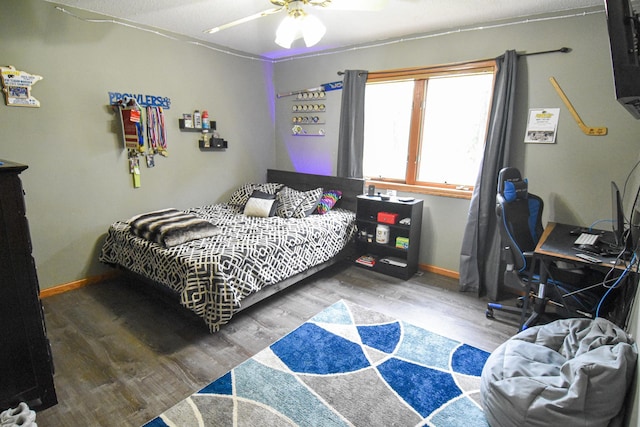 bedroom featuring ceiling fan, baseboards, and wood finished floors