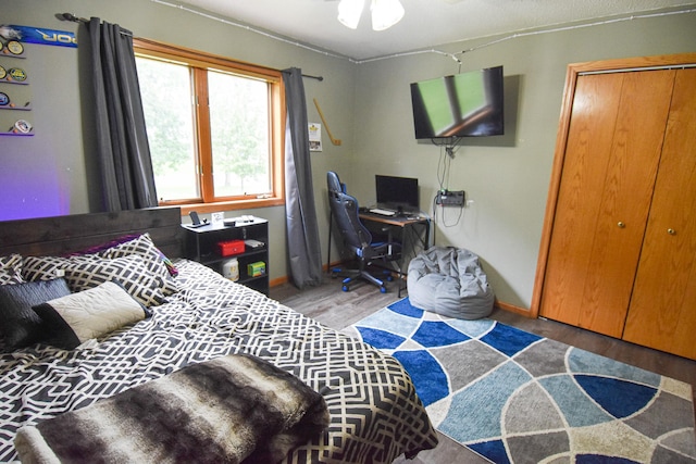 bedroom featuring a closet, baseboards, and wood finished floors