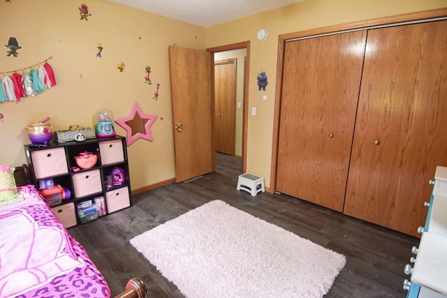 bedroom featuring baseboards, dark wood finished floors, and a closet