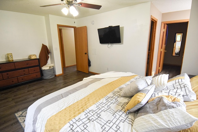 bedroom with ceiling fan, dark wood-style flooring, and baseboards