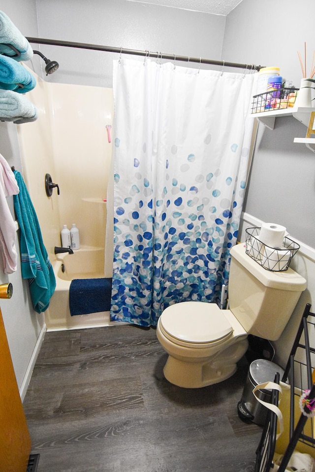 full bathroom with shower / tub combo, wood finished floors, toilet, and baseboards