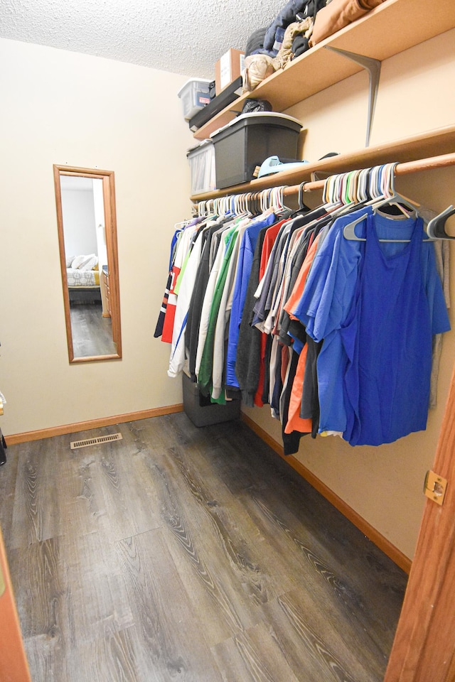 walk in closet with dark wood-style floors and visible vents