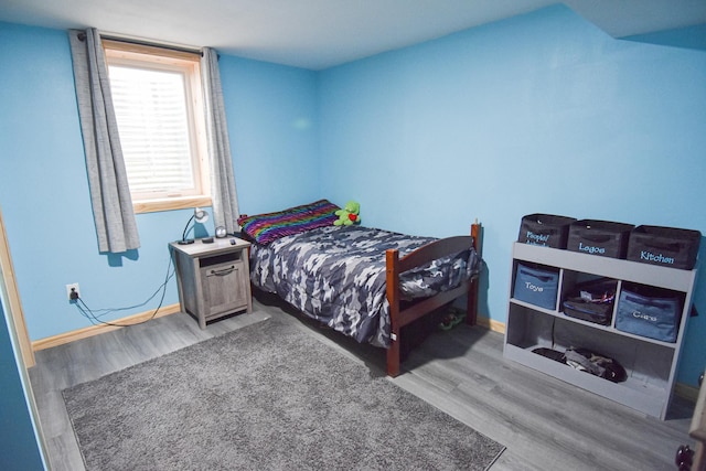 bedroom with baseboards and wood finished floors