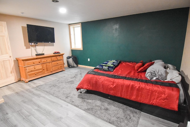 bedroom with light wood-style flooring and baseboards