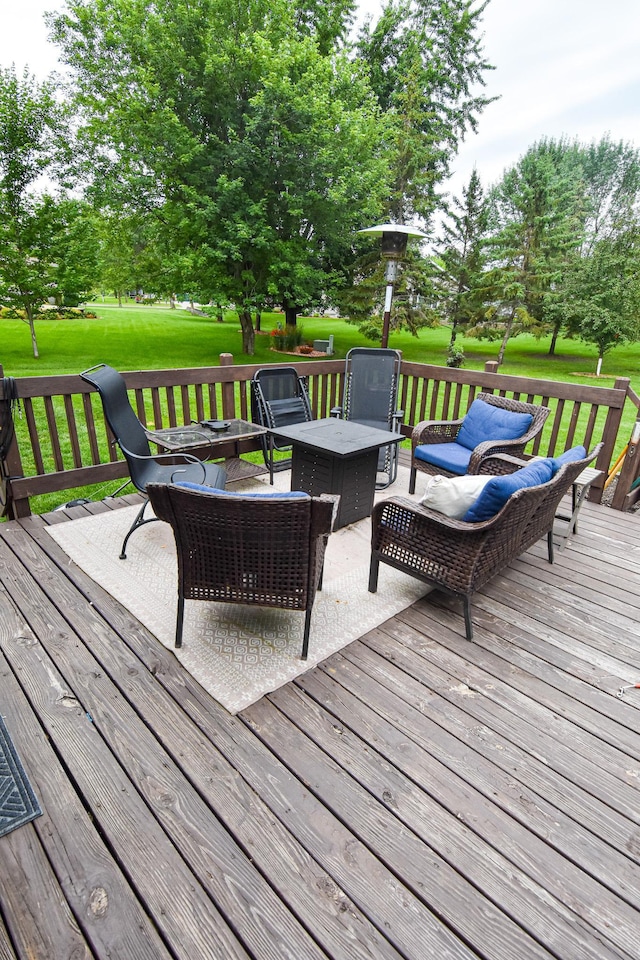 wooden deck featuring an outdoor living space with a fire pit and a lawn