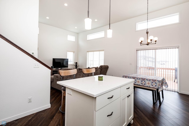 kitchen with dark wood-style floors, light countertops, white cabinetry, and a center island