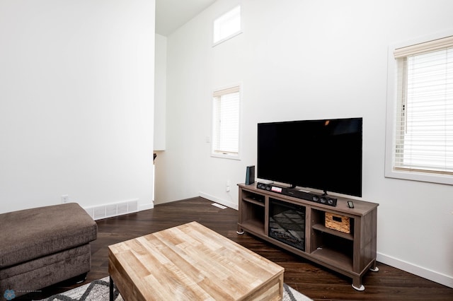 living area featuring dark wood-style floors, visible vents, and baseboards