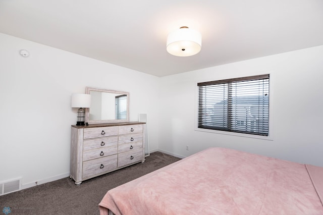 bedroom with visible vents, dark carpet, and baseboards