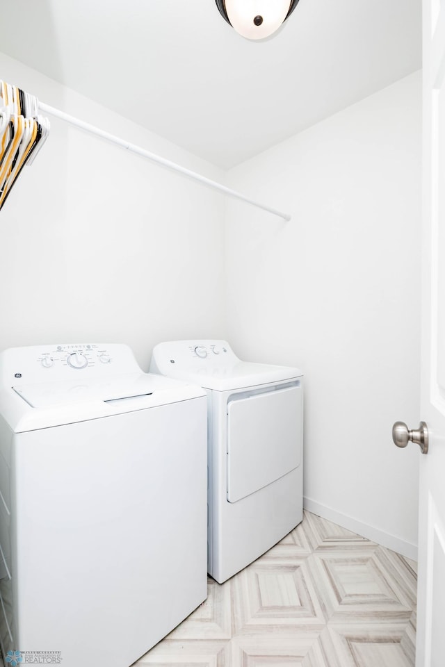 washroom with laundry area, baseboards, and washing machine and clothes dryer